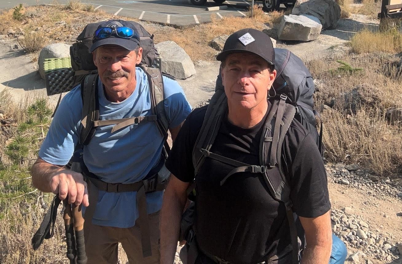Anton Bayer and his hiking partner Paul wearing loaded backpacks at the Caples Lake trailhead before a three-day Sierra trip